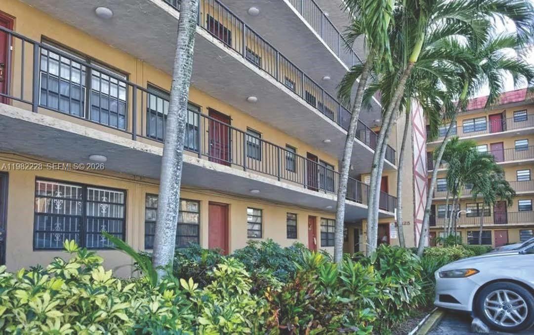 1325 West 68th Street, Unit 113 Hialeah, FL 33014 - Photo 12 of 14 a front view of a multi story building with a yard