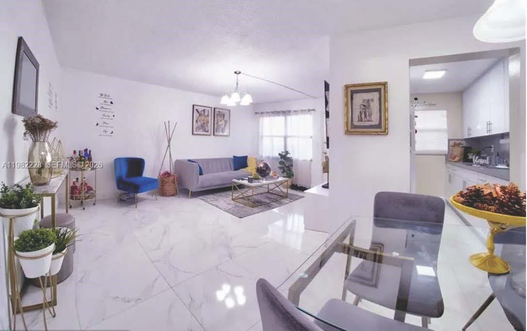 1325 West 68th Street, Unit 113 Hialeah, FL 33014 - Photo 5 of 14 a living room with furniture and a dining room