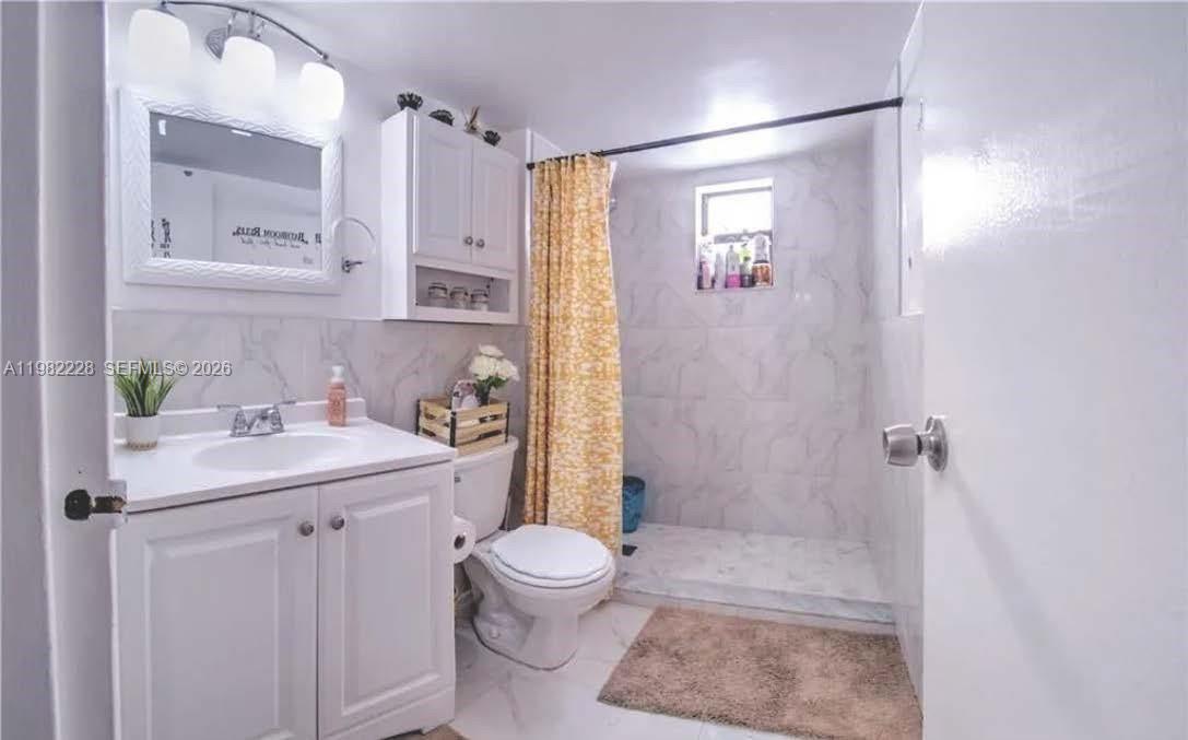 1325 West 68th Street, Unit 113 Hialeah, FL 33014 - Photo 9 of 14 a bathroom with a sink a toilet a mirror and shower