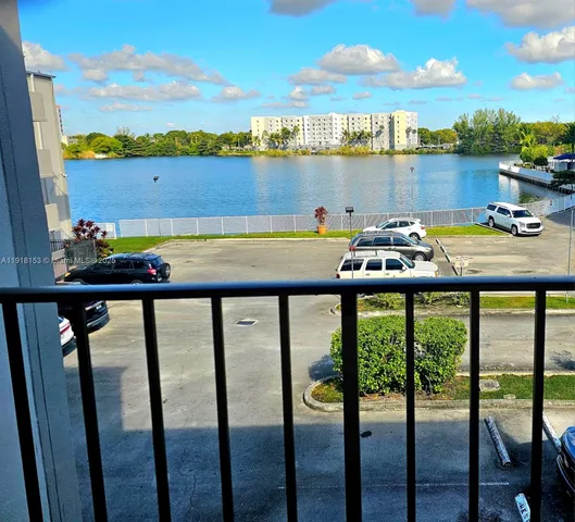 a view of a lake from a balcony with furniture