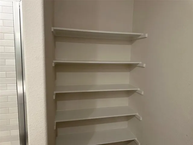 a view of walk in closet with empty racks