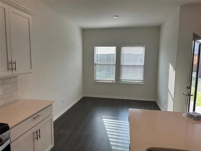 a close view of a refrigerator in kitchen with stainless steel appliances wooden floor