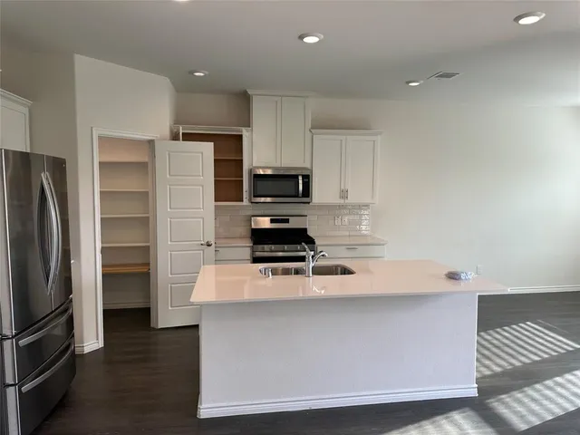 a kitchen with kitchen island a refrigerator and a stove