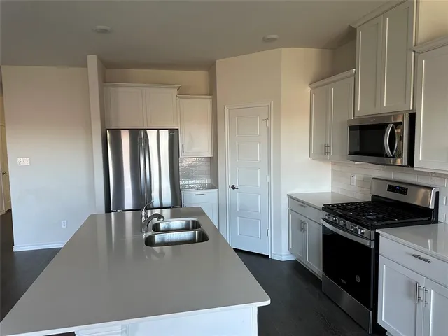 a kitchen with granite countertop a stove and a refrigerator