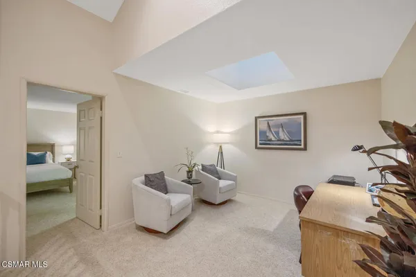 a living room with furniture and a view of bedroom