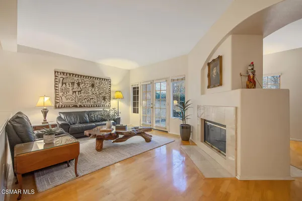 a living room with furniture large window and a fireplace
