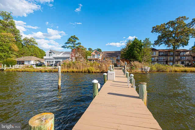 a kitchen with granite countertop a stove a sink a dining table and chairs with wooden floor