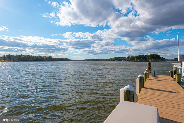 a kitchen with stainless steel appliances kitchen island granite countertop a stove a sink dishwasher and a refrigerator with wooden floor