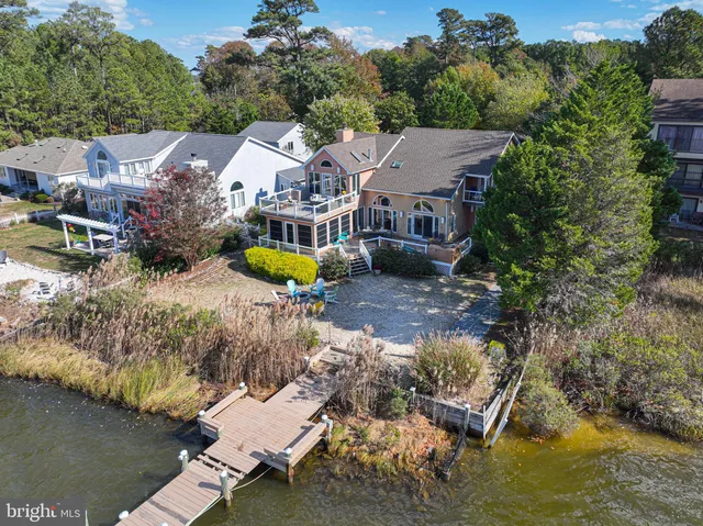 a kitchen with stainless steel appliances granite countertop a refrigerator a sink dishwasher a stove and white countertops with wooden floor