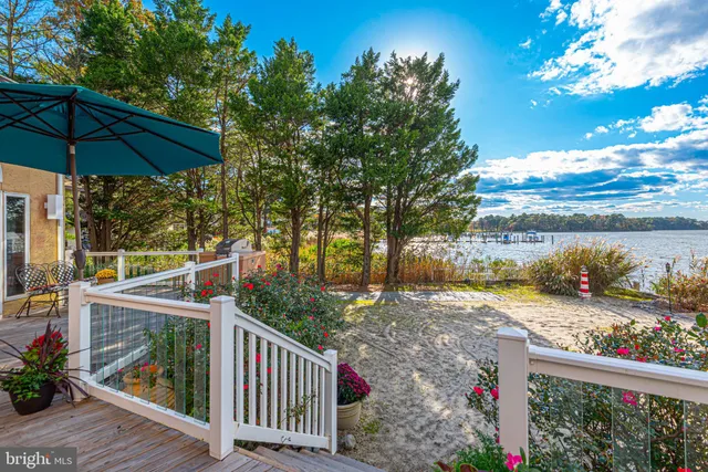 a dining room with wooden floor a chandelier a wooden table and chairs