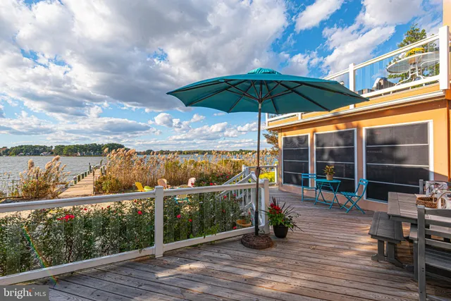 a view of a rooftop deck with couch and chairs