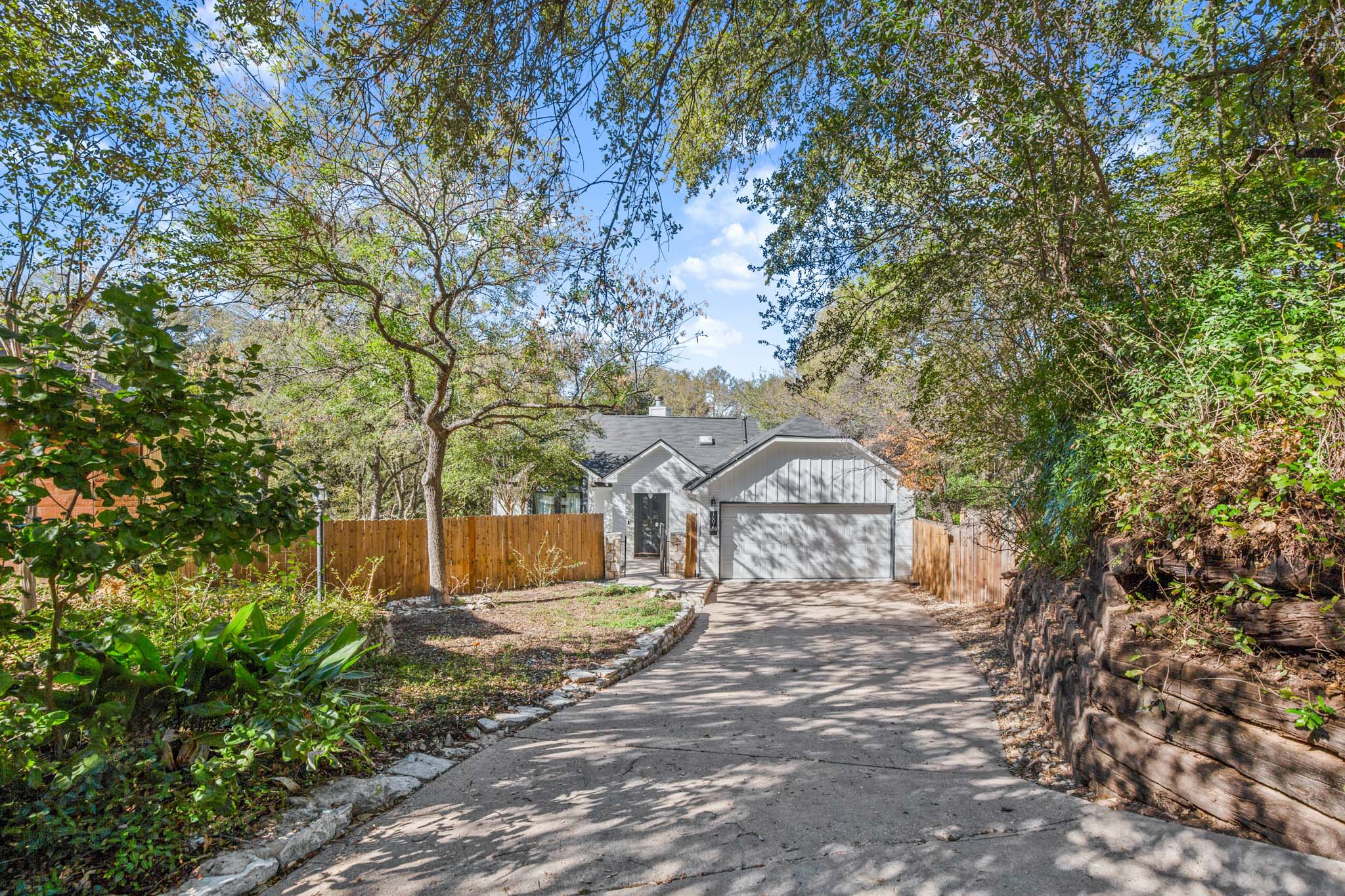 1601 Whitney Way Austin, TX 78741 - Photo 30 of 30 A private driveway leads to a modern home nestled amidst mature trees.