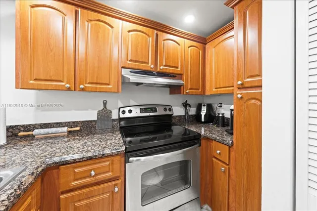 a kitchen with stainless steel appliances granite countertop a stove a sink and a microwave