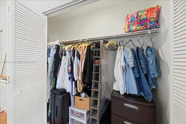 a view of walk in closet with clothes and shoes