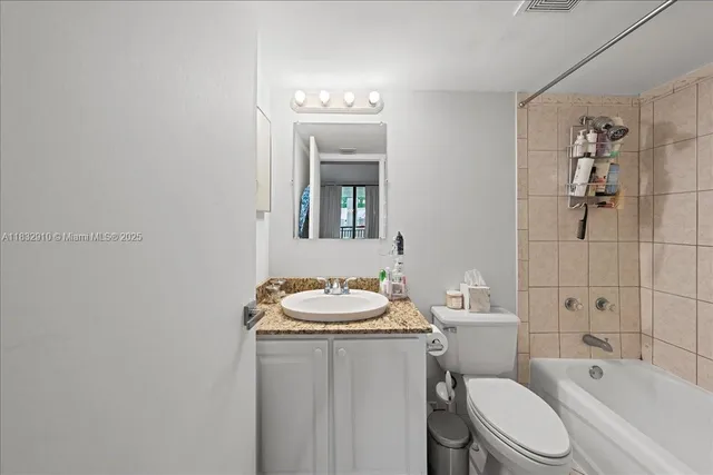 a bathroom with a sink toilet vanity tub and shower