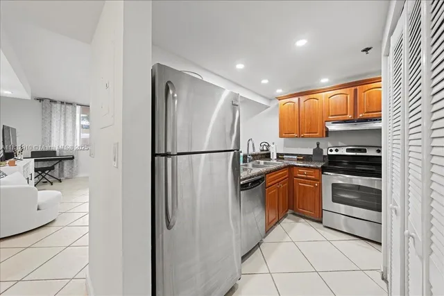 a kitchen with stainless steel appliances granite countertop a refrigerator sink and cabinets