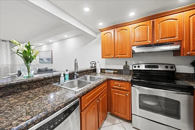 a kitchen with granite countertop stainless steel appliances a stove a sink and a microwave