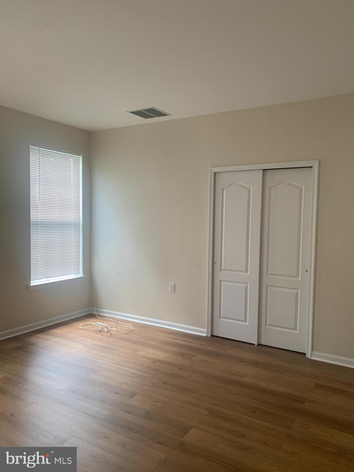 207 Devon Lane Hainesport, NJ 08036 - Photo 11 of 12 a view of an empty room with wooden floor and a window