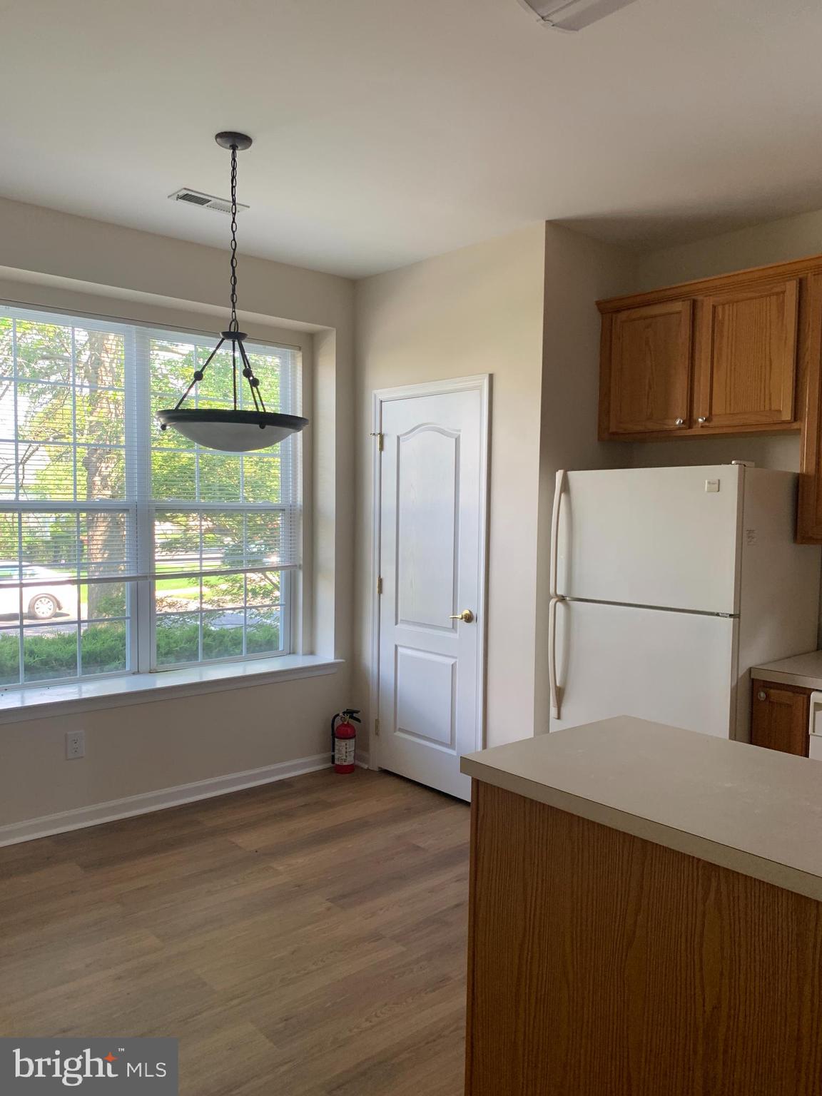 207 Devon Lane Hainesport, NJ 08036 - Photo 7 of 12 a view of a kitchen with a refrigerator cabinets and a wooden floor