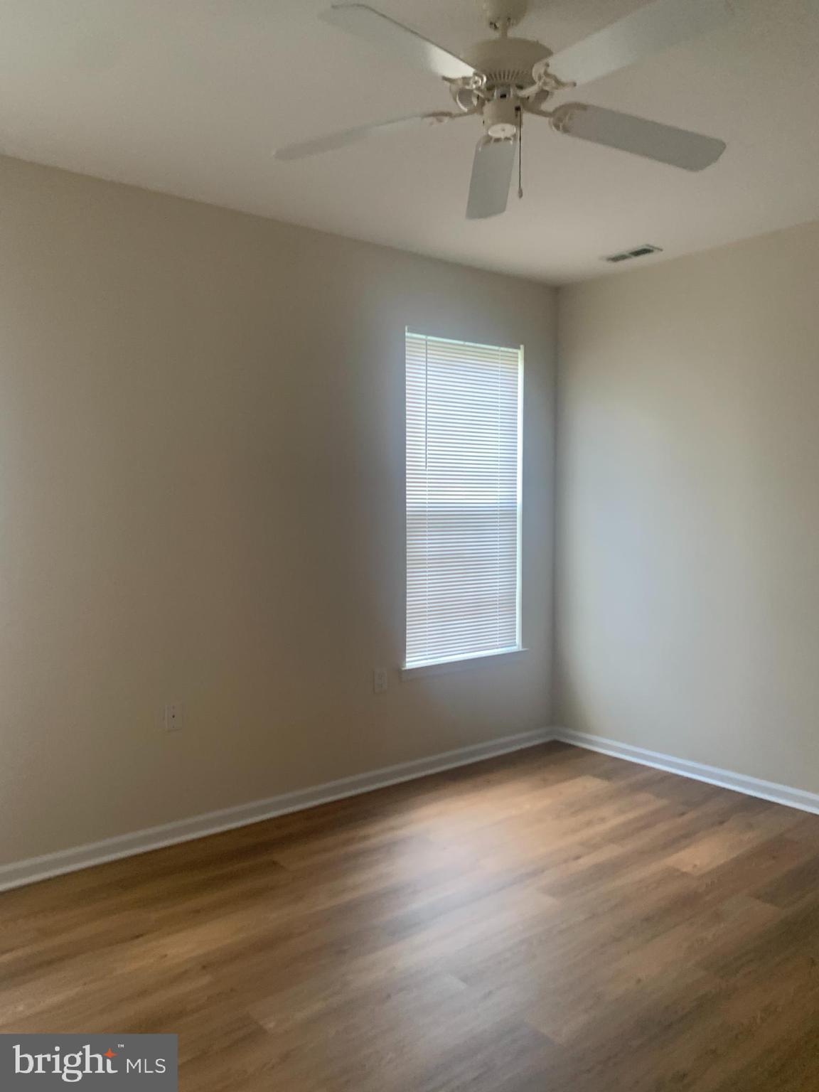 207 Devon Lane Hainesport, NJ 08036 - Photo 8 of 12 an empty room with a chandelier fan and windows