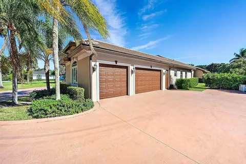 a view of a house with a big yard and large tree