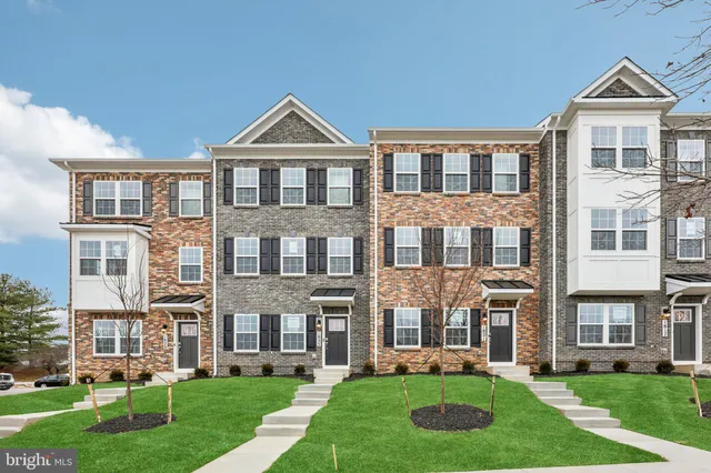 a front view of a house with a yard and trees