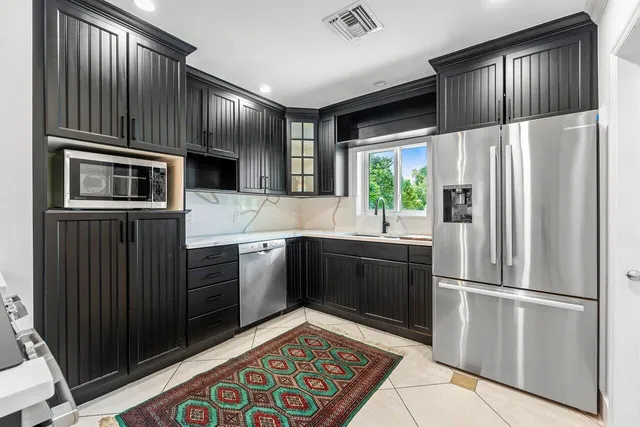a kitchen with stainless steel appliances granite countertop a refrigerator stove and sink
