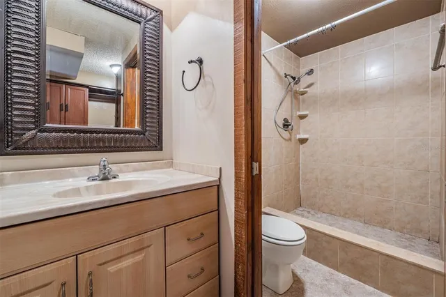 a bathroom with a granite countertop sink toilet and shower