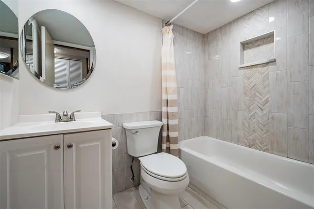 a bathroom with a toilet a sink a mirror a bathtub and vanity