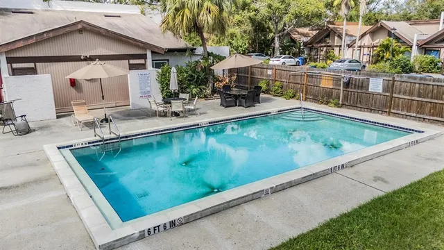 a view of a house with pool and chairs