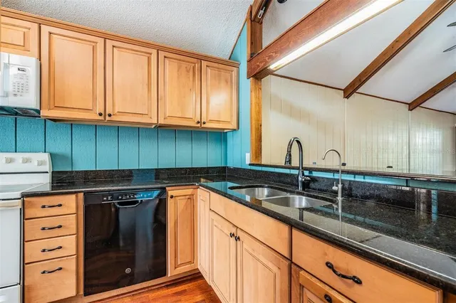 a kitchen with granite countertop a sink and cabinets