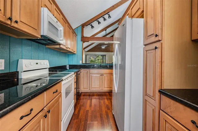 a kitchen with stainless steel appliances granite countertop a refrigerator and a stove