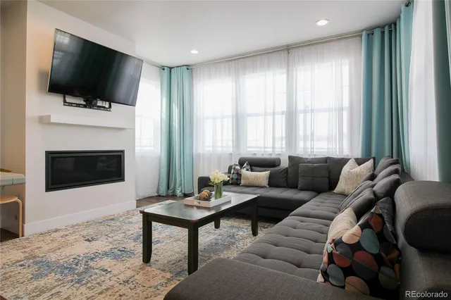 a living room with furniture a flat screen tv and a fireplace