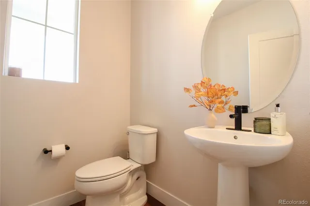 a bathroom with a sink toilet and mirror