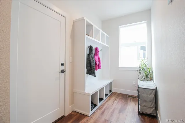 a view of hallway with window and wooden floor