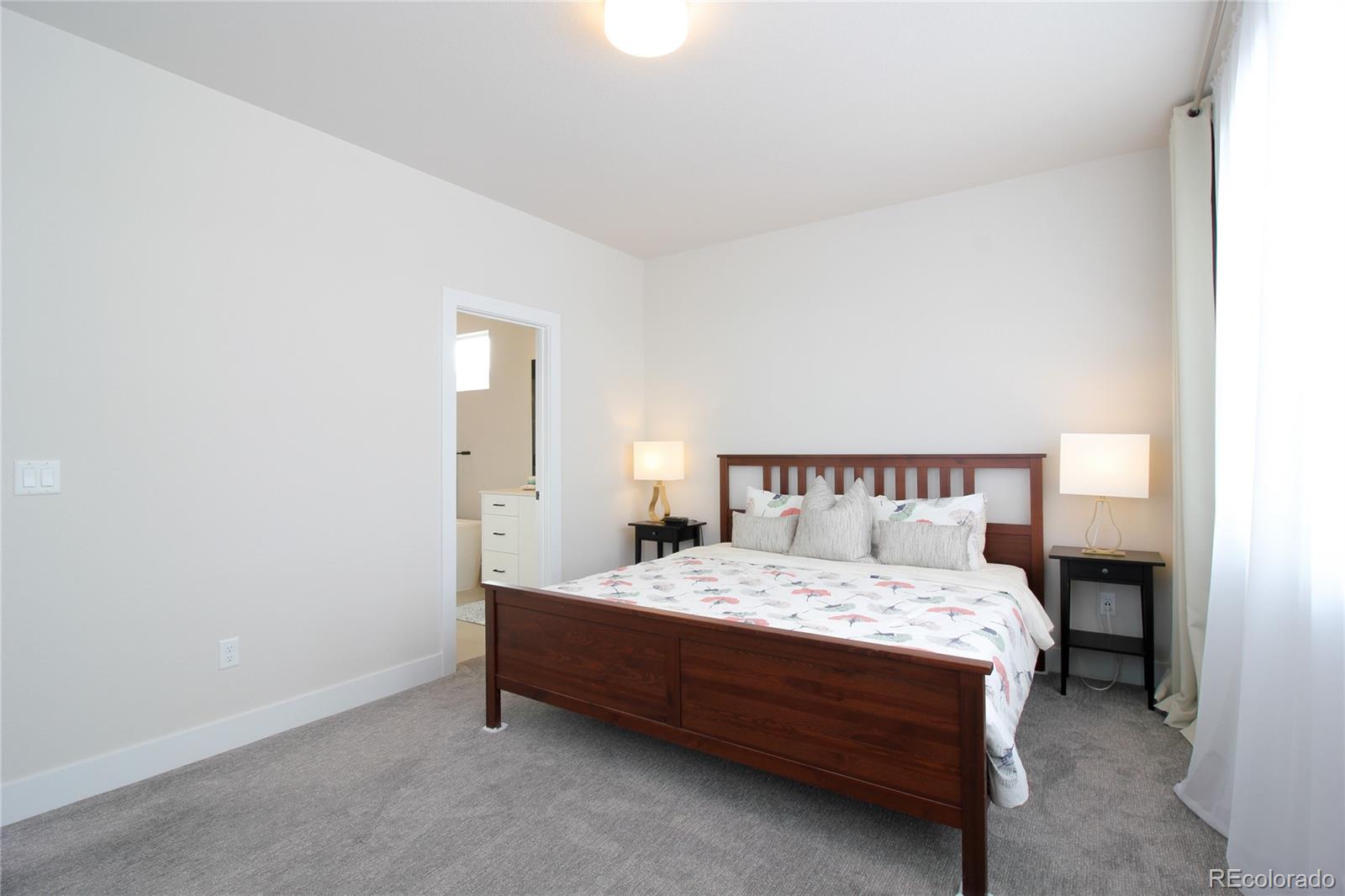 10394 Detroit Street Denver, CO 80229 - Photo 21 of 50 a bedroom with a bed and a lamp