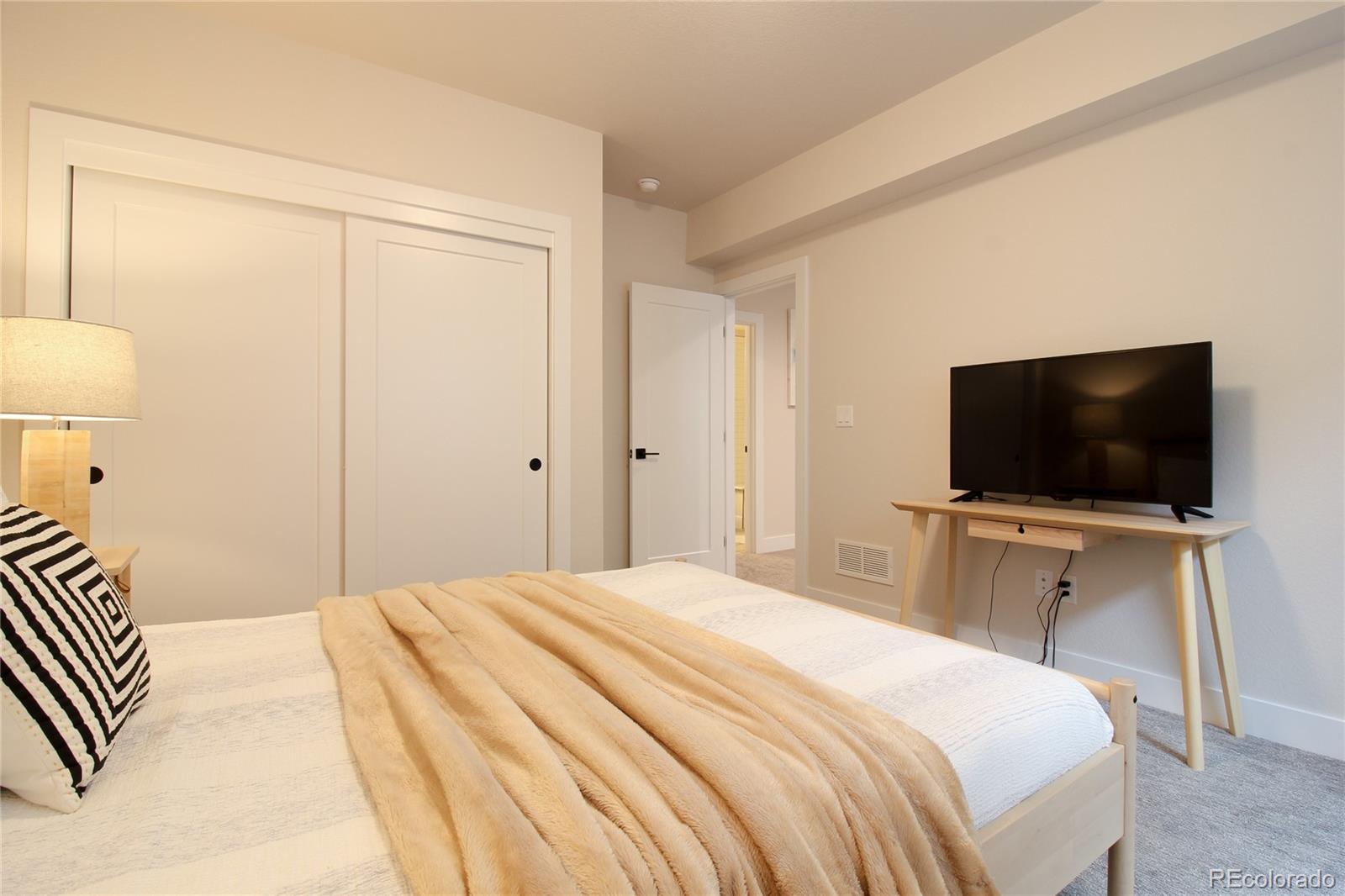 10394 Detroit Street Denver, CO 80229 - Photo 32 of 50 a bedroom with a bed and a flat screen tv