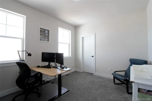 a view of a workspace with furniture and a window