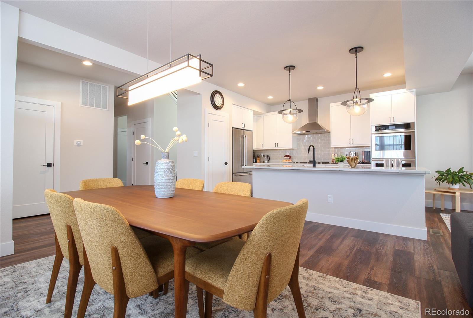 10394 Detroit Street Denver, CO 80229 - Photo 9 of 50 a dining room with stainless steel appliances kitchen island a table and chairs
