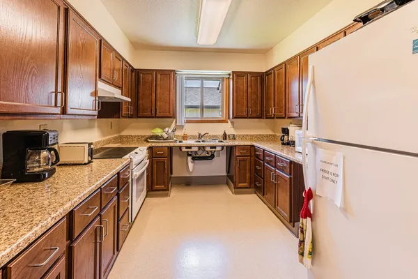 a kitchen with stainless steel appliances granite countertop sink stove top oven and cabinets