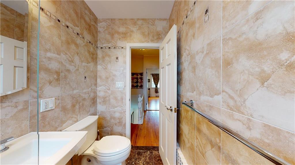 83 Gravesend Neck Road Brooklyn, NY 11223 - Photo 14 of 27 a bathroom with a granite countertop bathtub shower sink vanity and toilet