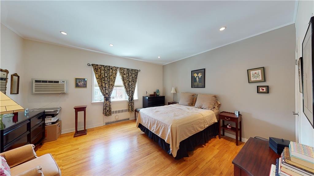 83 Gravesend Neck Road Brooklyn, NY 11223 - Photo 17 of 27 a spacious bedroom with a bed a window and dresser