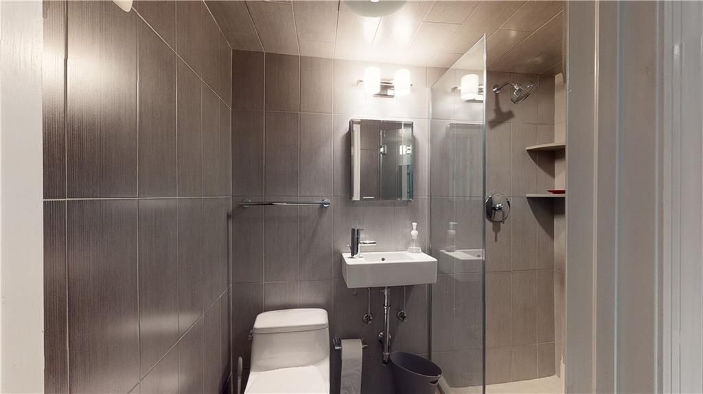 83 Gravesend Neck Road Brooklyn, NY 11223 - Photo 19 of 27 a bathroom with a toilet a sink and mirror