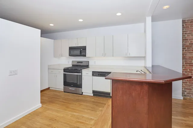 a view of a room with wooden floor and entryway
