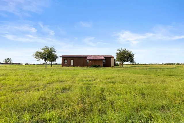 a view of an house with backyard space and trampoline