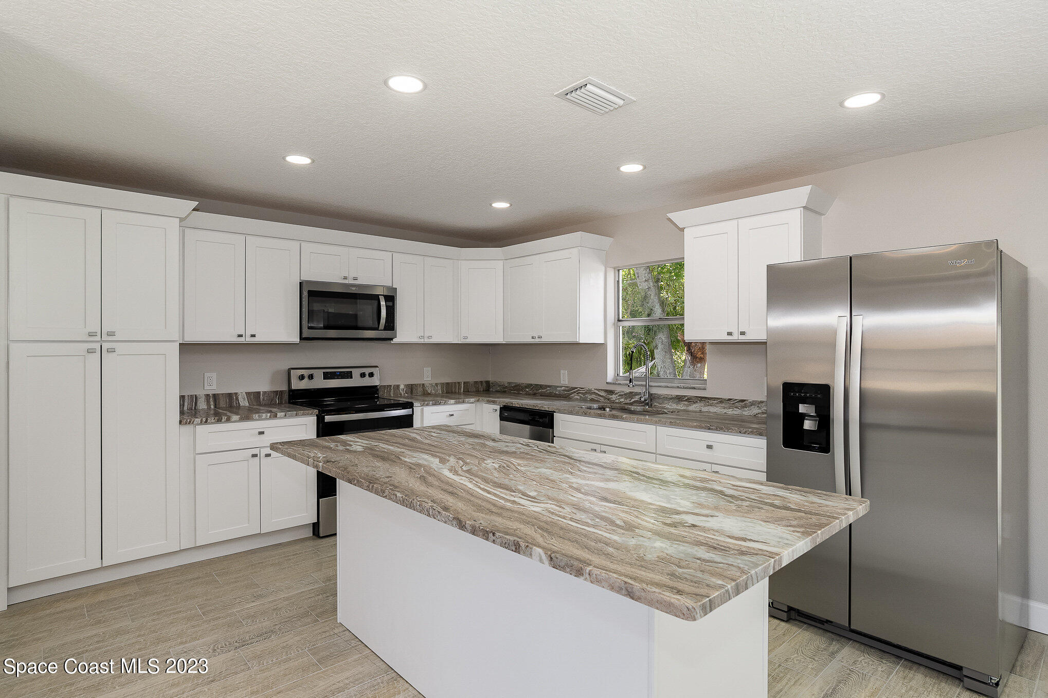 1339 Forest Drive Rockledge, FL 32955 - Photo 5 of 21 a kitchen with stainless steel appliances granite countertop a refrigerator a stove microwave and sink