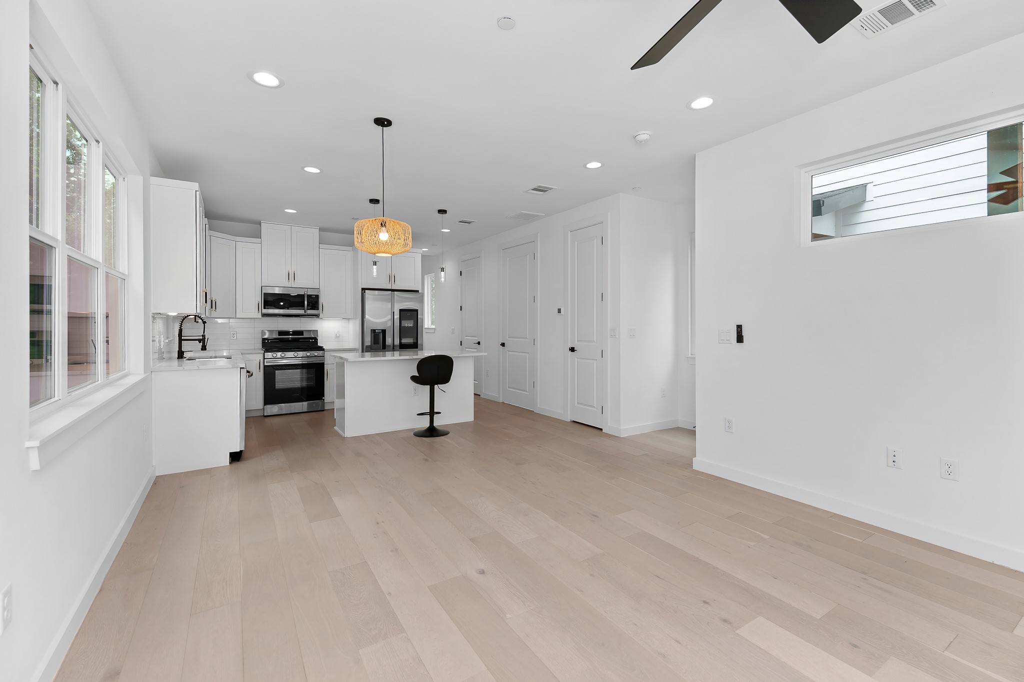 5305 Ledesma Road, Unit 4 Austin, TX 78721 - Photo 13 of 40 A well-lit, open-concept kitchen and living area features light hardwood flooring and modern white cabinetry.