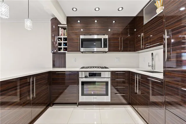 a kitchen with stainless steel appliances kitchen island granite countertop a stove and a sink