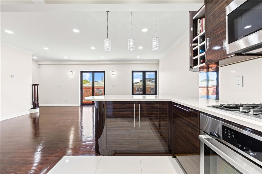 3165 Emmons Avenue, Unit PH3N Brooklyn, NY 11235 - Photo 10 of 33 a kitchen with stainless steel appliances kitchen island granite countertop a stove and cabinets
