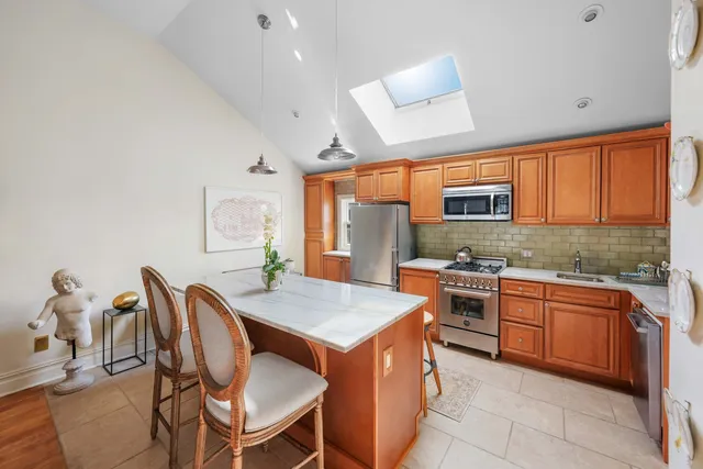a living room with furniture kitchen view and a wooden floor